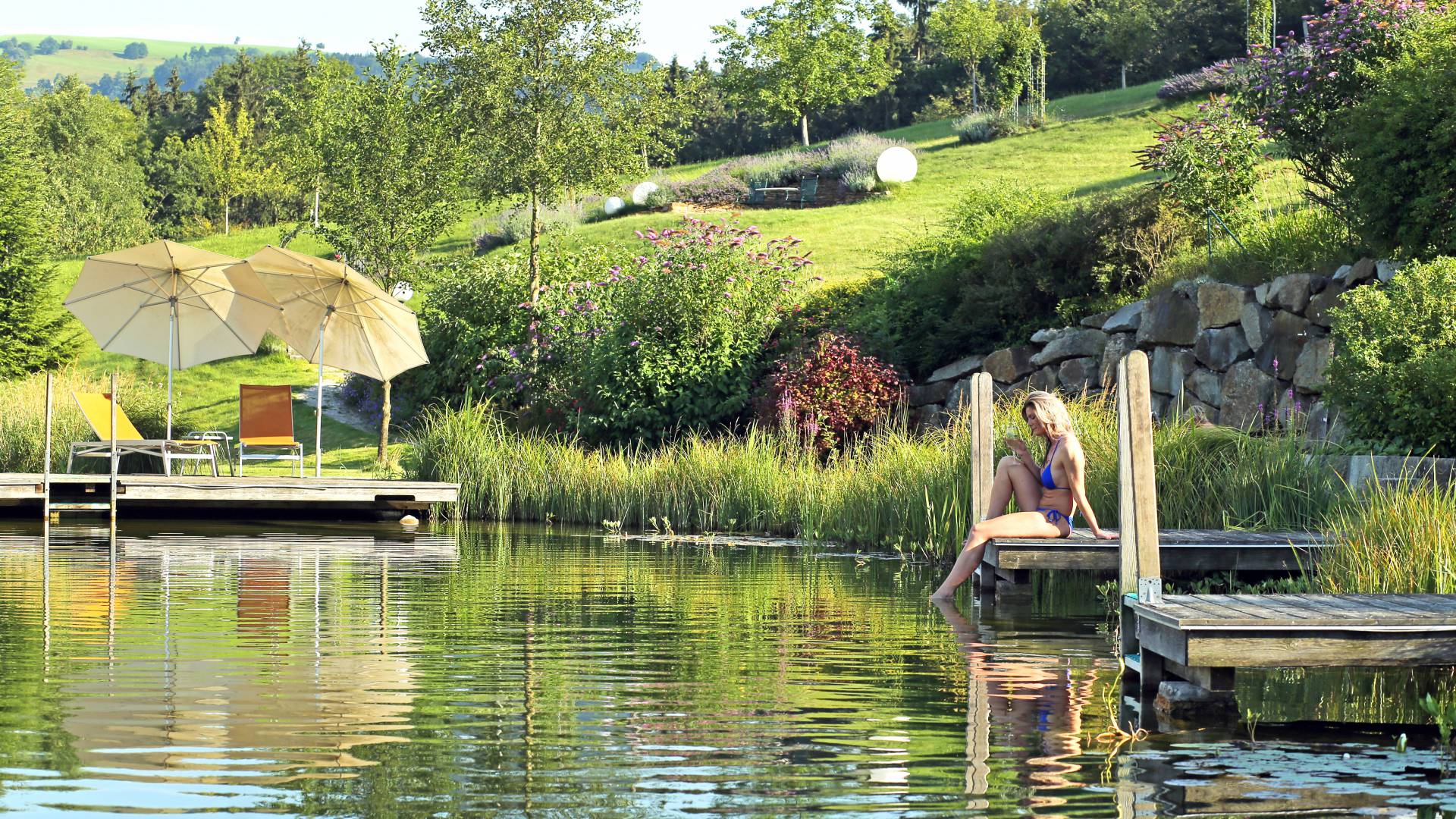 Frau beim Entspannen am Naturbadeteich im Wellnesshotel